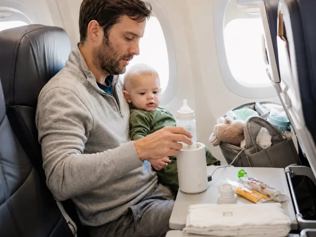 Réchauffer le biberon en avion : un papa utilise un chauffe-biberon nomade pour préparer le repas de bébé à bord