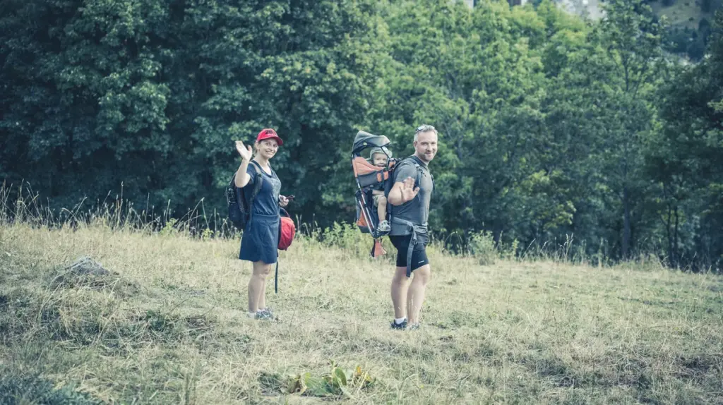 Vacances en famille avec un bébé : parents en randonnée d'été